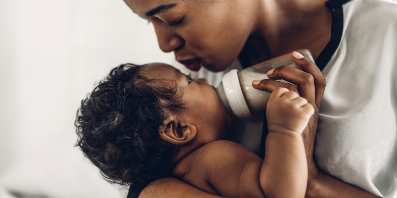 Woman holding and feeding her baby