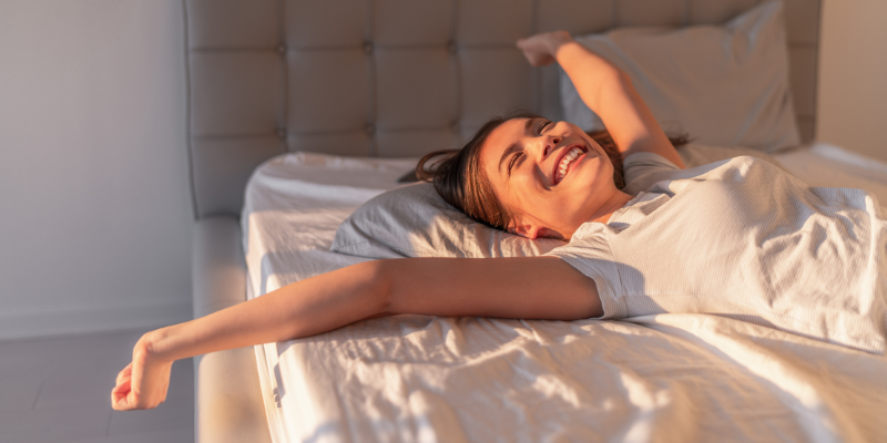 Smiling women in bed after orgasm
