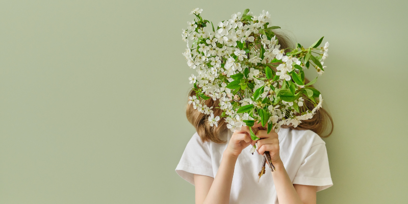 Girl holds natural organic flowers over her head