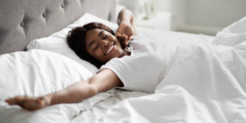 Pleased woman smiling in bed