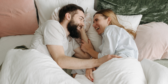 Post-pregnant women lies in bed with partner
