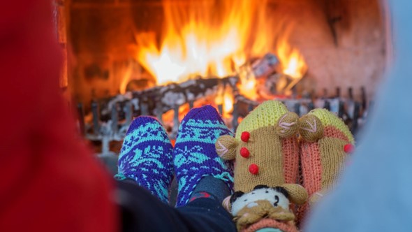 couples feet in christmas socks in front of fire