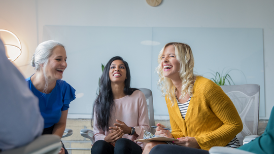 3 women chatting and laughing inside 